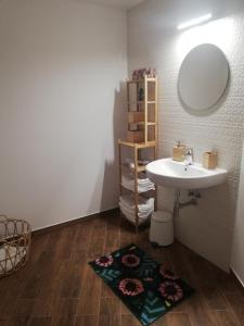 a bathroom with a sink and a mirror and a rug at Apartment MyMara No3 in Bešeňová +40 photos