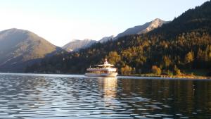 a cruise ship on a lake in the mountains at Haus Birke in Weissensee