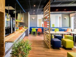 um restaurante com cadeiras coloridas e uma mesa em Ibis Budget Porte de Camargue em Saint-Martin-de-Crau