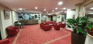 a lobby with red chairs and a waiting room at Hotel Europa in Biella