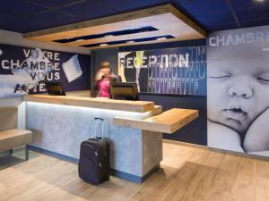 a woman standing at the counter of a baby store at ibis budget Lyon Centre Confluence in Lyon