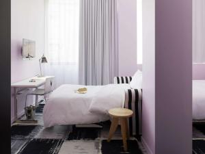 a bedroom with a bed and a desk and a table at Mama Shelter Bordeaux Centre in Bordeaux