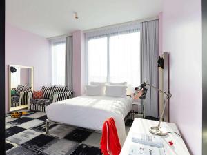 a bedroom with a bed and a table with a lamp at Mama Shelter Bordeaux Centre in Bordeaux