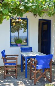 a blue table and two chairs and a window at Sunset Hotel in Agios Ioannis Kaspaka