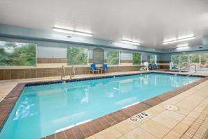 a large swimming pool with blue water in a building at Holiday Inn Express Hotel & Suites Marysville by IHG in Marysville