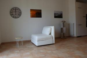 a white chair in a room with a clock on the wall at Myricae in Viareggio