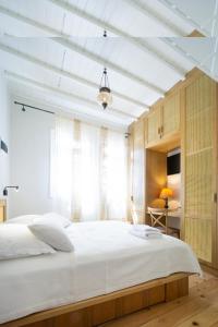 Un dormitorio con una gran cama blanca y una ventana. en Kallinikou Residence - private parking on demand -, en La Canea
