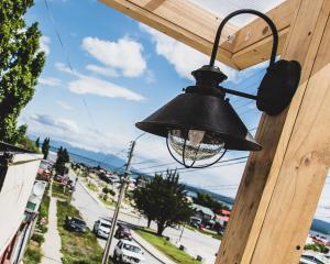 a bell hanging on the side of a building at Arte Brisa Hostal Boutique in Puerto Natales