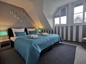 a bedroom with a bed with a blue comforter at Apartments mit Flair in Fehmarn