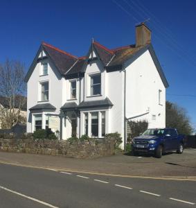 a white house with a car parked in front of it at The Wylfa in Abersoch
