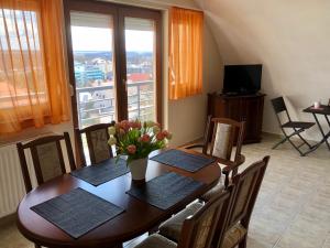 uma sala de jantar com uma mesa com flores em Savelij apartament em Hévíz