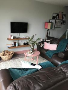 a living room with a couch and a tv at Ocean View one bedroom cozy apartment in Achill