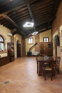 una sala da pranzo con tavolo e sedie in una stanza di Cascina Merlanetta ad Alessandria