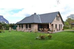 een huis met een tuin met groen gras bij Ferienhaus Dine in Born