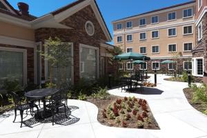 a patio with tables and chairs in front of a building at Staybridge Suites Rocklin - Roseville Area, an IHG Hotel in Rocklin