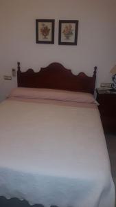 セビリアにあるApartamento San Benito "B"のベッドルーム1室(白い大型ベッド1台、壁に2枚の写真付)
