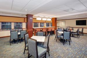 uma sala de jantar com mesas e cadeiras e uma televisão de ecrã plano em Holiday Inn Express Hotel & Suites Hampton South-Seabrook, an IHG Hotel em Seabrook