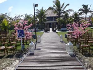 a walkway leading to a wedding venue with pink flowers at Rota do Sol Praia Hotel in Guaratuba