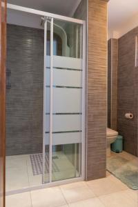a glass shower door in a bathroom at Cielle Epoque in Pefkohori
