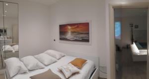 a white room with a bed and a picture on the wall at Il Leone Rosso over the hills of the Trabocchi in San Vito Chietino