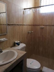 a bathroom with a toilet and a sink at Hotel California Panama in Panama City