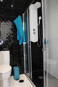 bagno con doccia e asciugamano blu di Golden Loft Caparica a Costa da Caparica Altre 30 foto