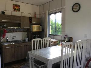 uma cozinha com uma mesa e cadeiras, uma mesa e uma janela em bei Mot em Pomerode