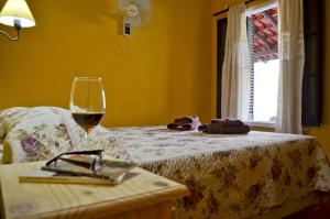 Posada Villapancha في سان خافيير: كوب من النبيذ يجلس على رأس سرير