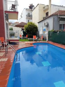 una gran piscina azul en medio de un edificio en Studios Finikes, en Limenas