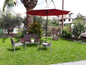 a table and chairs and an umbrella in the grass at Studios Finikes in Limenas