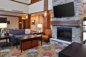 a hotel room with a fireplace and a tv at Staybridge Suites Rochester, an IHG Hotel in Rochester