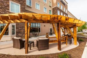 a wooden pergola with chairs and tables on a patio at Staybridge Suites Knoxville West by IHG in Knoxville