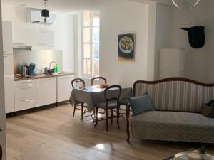 uma sala de estar com mesa e cadeiras e uma cozinha em COSY CENTRE HISTORIQUE em Arles