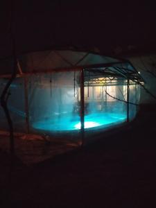 a swimming pool with a tent in the dark at Къща за гости с минерална вода "Терма Асклепий" in Kyustendil