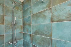 a bathroom with a shower with blue tiles at Superhost UK, FREE Parking, Fireplace, Bath City Center Luxury Maisonette! in Bath