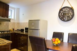 een keuken met een tafel en een klok aan de muur bij Zagreb Creative Apartments APP 2 in Zagreb