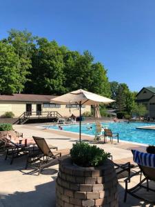 東史特拉斯堡的住宿－Pocono Villas Resort，一个带椅子和遮阳伞的游泳池以及游泳池