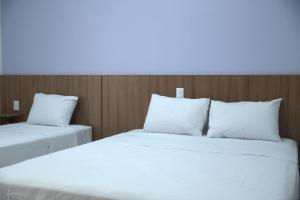 2 bedden met witte kussens in een kamer bij Big Hotel in Imperatriz
