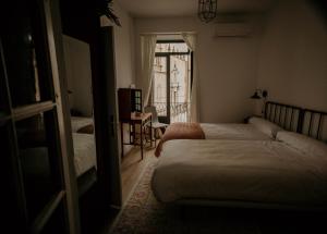 1 dormitorio con 2 camas y ventana en Casa da Catedral Ramona, en Badajoz