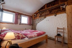 1 dormitorio con 1 cama y 2 ventanas en Almhaus Dachsteinblick am Feuerkogel, en Ebensee