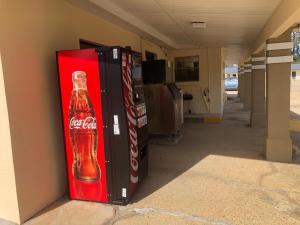 a coca cola vending machine sitting in a hallway at Liberty Inn - Collins in Collins