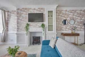 a living room with a blue couch and a fireplace at Superhost UK, FREE Parking, Fireplace, Bath City Center Luxury Maisonette! in Bath