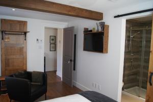 a bedroom with a bed and a television on a wall at Restaurant et Gite Les Passionnés in Val-David