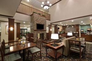 a hotel lobby with tables and chairs and a fireplace at Staybridge Suites Tucson Airport, an IHG Hotel in Tucson