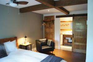 a bedroom with a bed and a chair and a fireplace at Restaurant et Gite Les Passionnés in Val-David