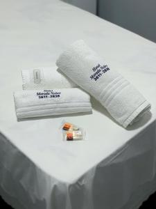ein weißes Bett mit Handtüchern und einer Tube Zahnpasta in der Unterkunft Hotel Morada Nobre in Barreiras