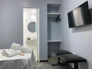 a room with a bed and a chair and a tv at Hotel Morada Nobre in Barreiras