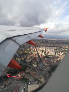 a view of the wing of an airplane flying over a city at Napoli Bed & Fly in Naples