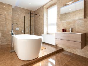 a bathroom with a tub and a shower and a sink at Moderne City Appartments im Stadtzentrum in Chemnitz