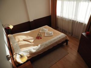 a small bed with two towels and flowers on it at Dom Gościnny 8 km od Suntago, Deepspot in Radziejowice